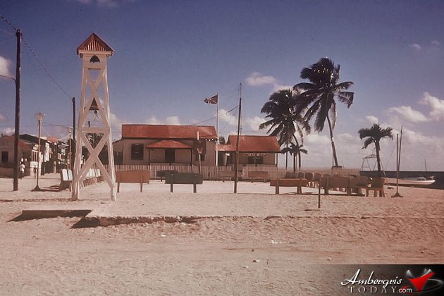 San Pedro Central Park with concrete benches and church bell tower and in the background the police station with the Union Jack flag